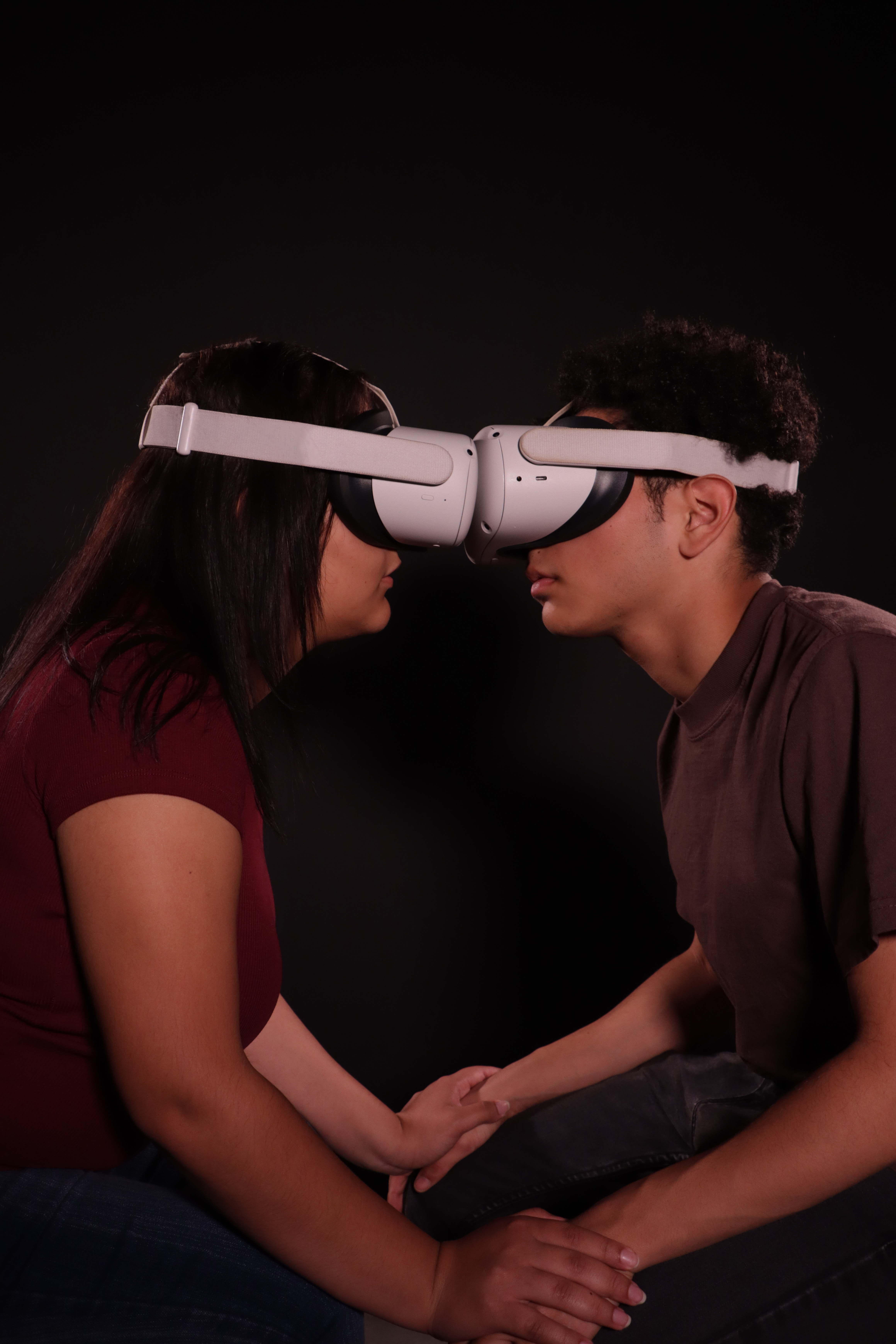 The Winning Photo: two fellow students wearing virtual reality goggles head to head while holding hands.